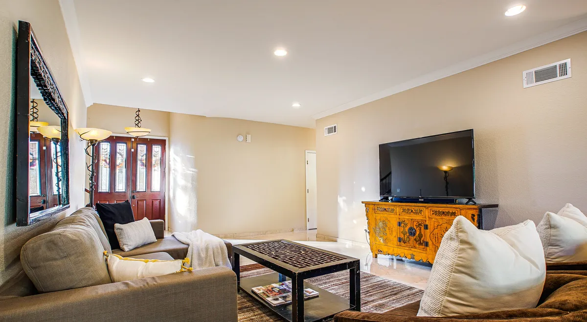 A comfortable second living room with a sofa, coffee table, television, and decorative accents. The room is designed for relaxation, watching TV, or spending time with family and friends.